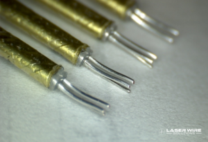 Prepared twinax cable end showing two conductors, retained dielectric, and shield setback
